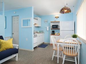 可可比奇南海滩汽车旅馆 - 可可海滩的厨房拥有蓝色的墙壁,配有桌椅