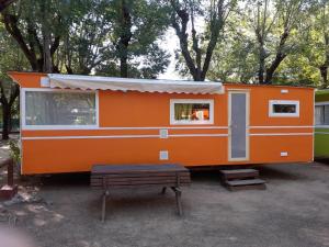 布拉内斯夏巴奈尔露营地的橙色拖车,带长凳和桌子