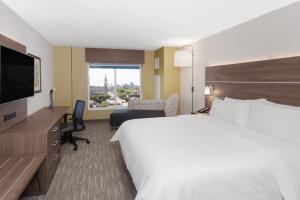 渥太华Holiday Inn Express & Suites Downtown Ottawa East, an IHG Hotel的酒店客房设有一张大床和一张书桌。