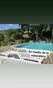 GuachacaHostal Brisas del Campo的游泳池前的一张床位