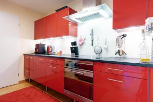 艾姆敦Wohlfühlresidenz auf dem Sonnenplateau的红色的厨房配有红色橱柜和炉灶