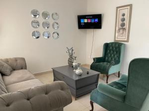 埃莫西约CASA PONIENTE的客厅配有沙发、两把椅子和电视