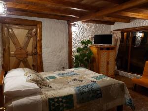 奥塔瓦洛ATALLARO Hospedaje的一间卧室配有一张床,墙上配有电视