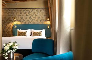 巴黎双岛酒店 - 巴黎圣母院的一间卧室配有一张床和一张蓝色椅子