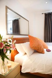 伦敦City Inn Russell Square的卧室配有一张壁挂镜子的床