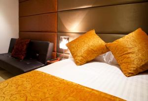 伦敦City Inn Russell Square的一间卧室配有带两个枕头的床和一张沙发