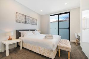 悉尼BRID243FL - The Terrace on Bridge的白色卧室配有床、桌子和椅子