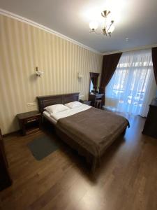 TarashanyGeorg Park Hotel的一间卧室配有一张床和一个吊灯