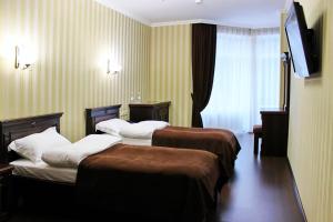TarashanyGeorg Park Hotel的酒店客房设有两张床和电视。