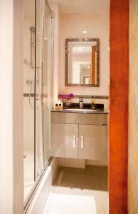 伦敦City Inn Russell Square的浴室配有盥洗盆和带镜子的淋浴