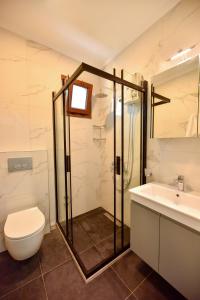 费特希耶Fethiye YALI SUITES的带淋浴、卫生间和盥洗盆的浴室