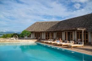 姆托瓦姆布Manyara's Secret的一个带游泳池的度假胜地,人们坐在庭院里