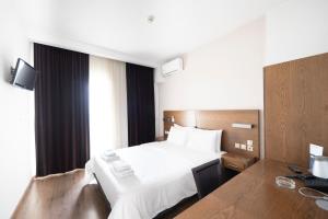塞萨洛尼基罗托达酒店的配有一张床和一张书桌的酒店客房