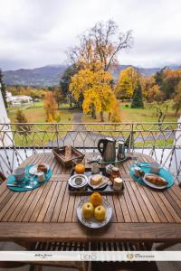 阿热莱斯加佐斯特Le Balcon du Parc, entre Lourdes et Gavarnie的阳台上的木桌和食物