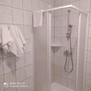 埃格尔Bacchus Panzió的浴室提供白色毛巾和淋浴。