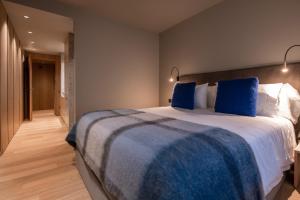 埃尔塔特Vip Residences Andorra的一间卧室配有一张带蓝色枕头的大床