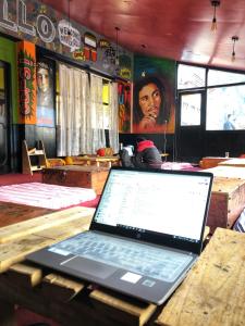 马拉里La Vaca India Manali的坐在餐厅木桌旁的笔记本电脑