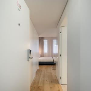 里斯本Lisbon Serviced Apartments - Mouraria的白色的房间,远处配有一张床