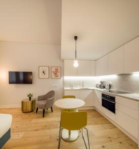 里斯本Lisbon Serviced Apartments - Mouraria的厨房配有白色橱柜和桌椅