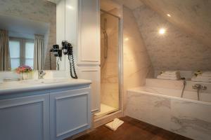 布鲁日河滨之家 - 豪华旅馆的浴室配有水槽、淋浴和浴缸。