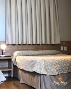 塞蒂拉瓜斯Real Hotel的一间卧室设有一张床和一个大窗户