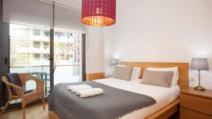 巴塞罗那RAMBLA BEACH Barcelonastuff Apartments的一间卧室配有一张带椅子的床和一扇窗户