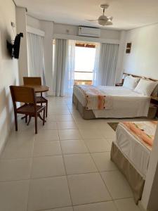 伊利亚贝拉Hotel Vista Bella的酒店客房带两张床和一张桌子以及椅子。