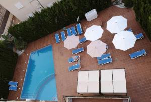 松塞尔韦拉Apartamentos Sema的享有带遮阳伞和游泳池的大楼的顶部景致