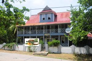 圣安德烈斯Coconut Paradise Lodge的蓝色房子,有红色屋顶