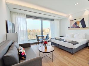 雅典Verde Apartments的一间卧室配有一张床、一张沙发和一张桌子