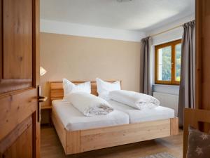 文斯Haus Ausblick的卧室配有带白色枕头的床和窗户。