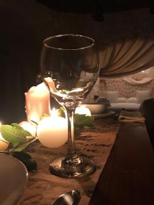 阿尔贝罗贝洛Trulli Aria di Casa的坐在带蜡烛的桌子上的葡萄酒杯