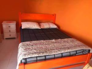 PortelaCasa helena的橙色墙壁的房间里一张小床