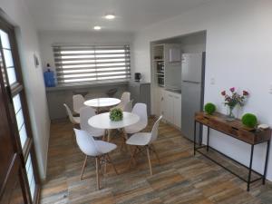 维纳德马Carolina Hostal的厨房以及带2张桌子和白色椅子的用餐室。