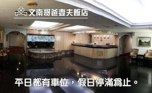 台南文南哥爸妻夫飯店的酒店大堂设有前台和电视。