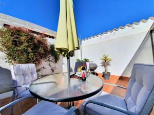 马略卡岛帕尔马Casa cercana a Santa Catalina的庭院里配有桌椅和遮阳伞