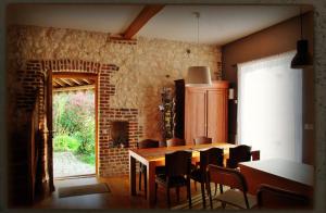 Mont-Saint-Éloi切斯非凡度假屋的一间设有桌椅和砖墙的用餐室