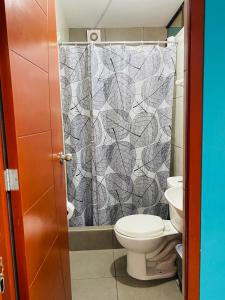 利马Sunset Hostel Airport的一间带卫生间和淋浴帘的浴室