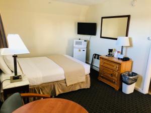 旧奥查德比奇海崖汽车旅馆的酒店客房配有床、桌子和镜子