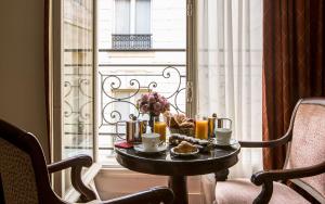 巴黎Hôtel des Saints Pères - Esprit de France的窗户前的桌子上放着食物