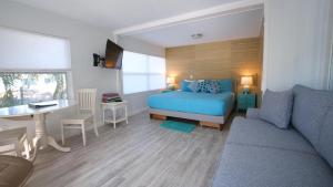 西耶斯塔岛BeachPoint Cottages的一间卧室配有一张床、一张桌子和一张沙发