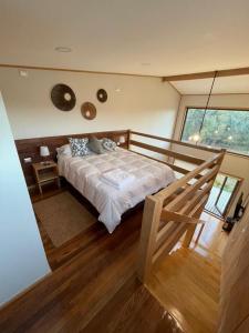 琼奇Cabañas Arrayanes de Huillinco en Chiloé的一间卧室设有一张床和一个大窗户