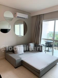 萨利诺波利斯Apartamento em Resort - Exclusive的一间卧室配有一张床、镜子和一张桌子