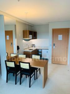 萨利诺波利斯Apartamento em Resort - Exclusive的厨房以及带木桌和椅子的用餐室。