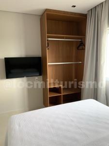 萨利诺波利斯Apartamento em Resort - Exclusive的一间卧室配有一张床和一台平面电视
