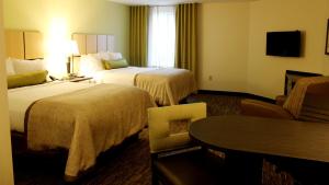 苏城苏城南山烛木套房酒店的酒店客房设有两张床和一张桌子。