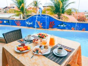 阿奎拉兹Planet Dunas Residence的一张带早餐食品的桌子和一个位于后面的游泳池