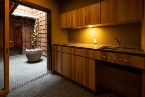 高冈市民家ホテル「金ノ三寸」(かねのさんずん）的一个带水槽和盆栽的厨房