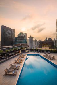 新加坡voco Orchard Singapore, an IHG Hotel的一座带躺椅的建筑屋顶上的游泳池