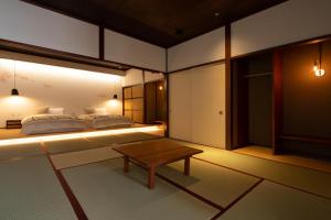 高冈市民家ホテル「金ノ三寸」(かねのさんずん）的一间卧室配有两张床和一张茶几